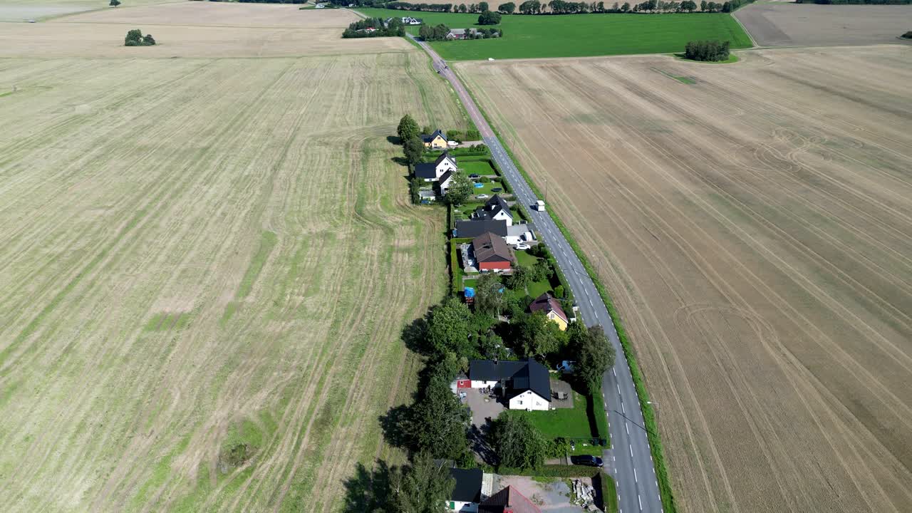 Rural fields and houses as a car drives pass in H&auml;sslunda near M&ouml;rarp in Sk&aring;ne, Sweden