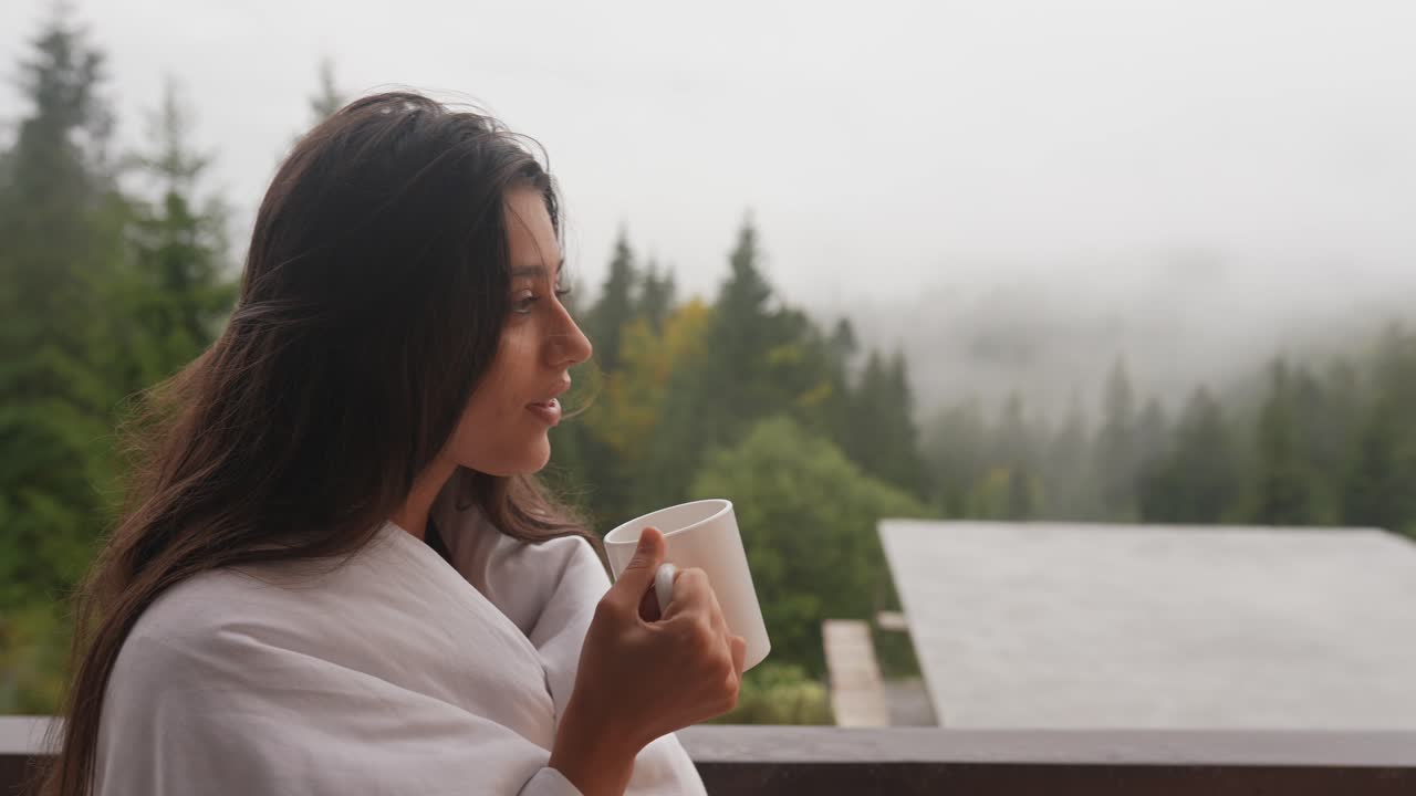 산의 발코니에서 커피를 마시는 여자
