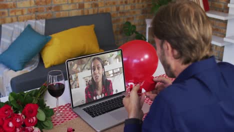 diverse couple on a valentines date video call man showing ring to woman on laptop screen