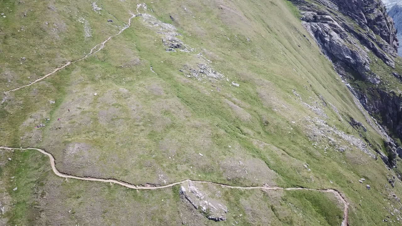 campo de hierba en los alpes suizos, camino de montaña para caminantes y ciclistas de descenso, vista aérea de drones