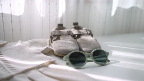 sandalias de bebé y gafas de sol en blanco