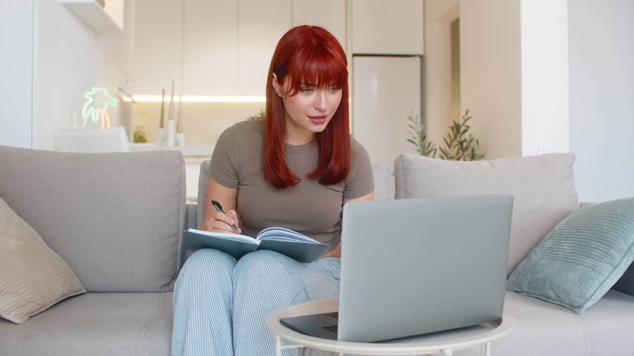 Young woman opens laptop and notebook starts weekly planning writes goals and task schedule for week