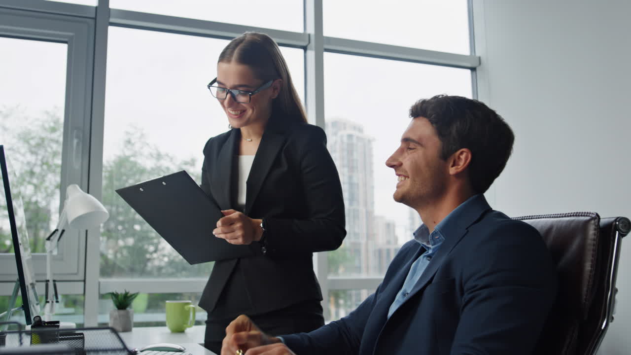 Equipo de negocios dándose la mano discutiendo un proyecto en la oficina. Asistente sonriente.