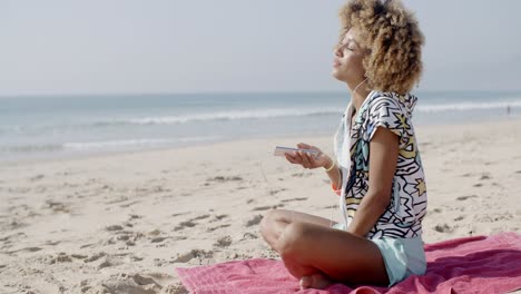 woman listening to music on the beach
