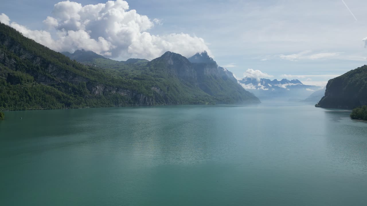 Vaste étendue d'eau turquoise ornant les montagnes alpines, vue aérienne.