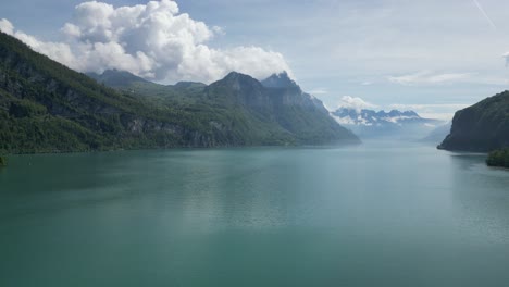 Riesige-Türkisfarbene-Wasserfläche,-Die-Die-Alpenberge-Schmückt,-Luftaufnahme