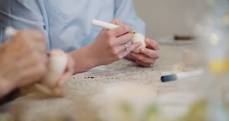 Happy-Easter-Close-Up-Of-Grandfather-And-Granddaughter-Hands-Coloring-Easter-Eggs-