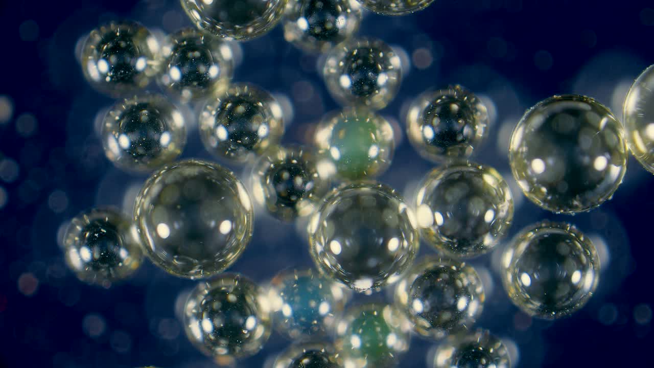 Ion-exchange resin beads in water filter between activated charcoal granules under microscope