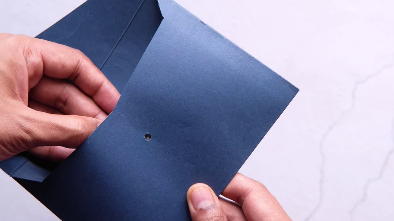 manos sosteniendo un sobre con dinero dentro