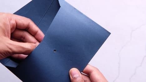 manos sosteniendo un sobre con dinero dentro