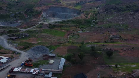drone reveals expansive quarry site in abuja, nigeria, displaying rugged terrain and machinery. aerial highlights intricate layout of infrastructure under soft afternoon light in rural africa