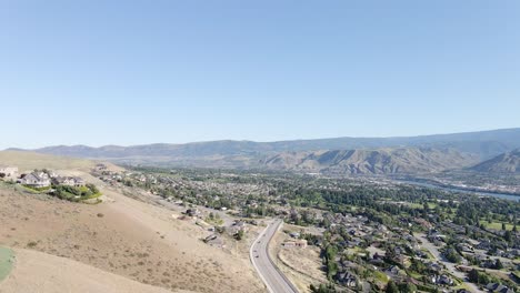 view of different green trees and mountains with bright blue sky above in wenatchee, washington - aerial shot