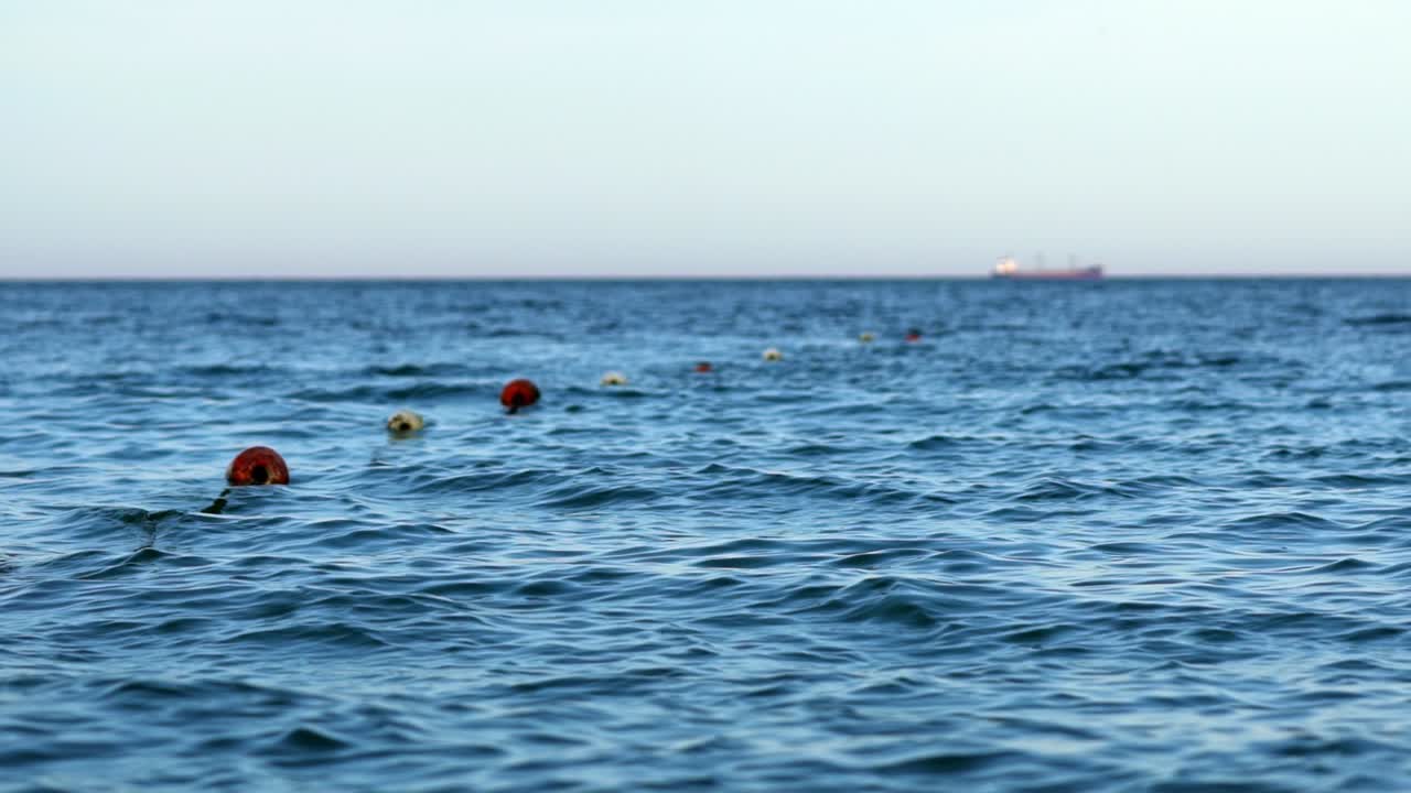 Floating buoys on water surface. Beautiful sea background. Breathtaking view of blue water under clear sky.