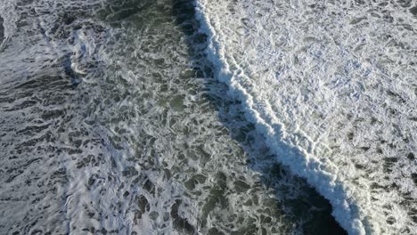 Rolling-waves-off-the-coast-of-South-Bali-just-after-sunrise,-aerial