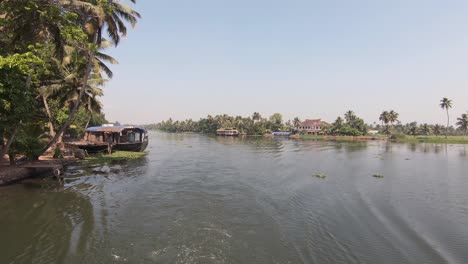 view from sailing boat of inhabited river shores at alappuzha or alleppey, india