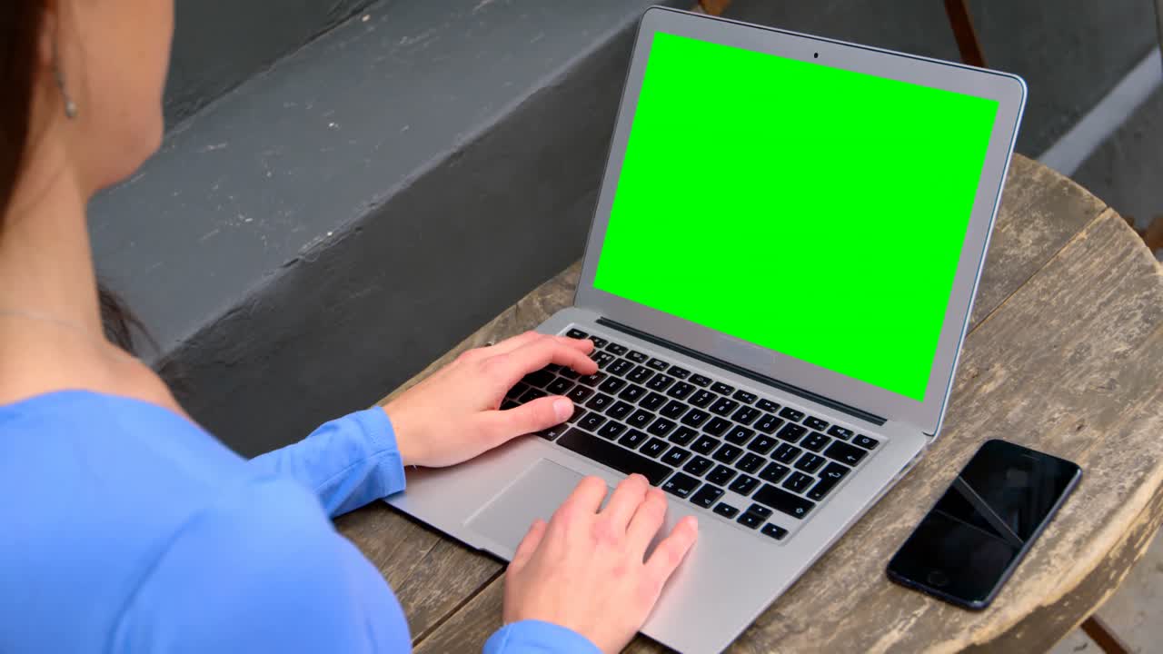Mid section of woman using laptop on table in outdoor cafe 4k