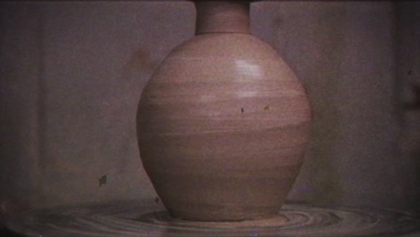 the potter makes a jug of clay. vintage effect. a man makes a vase on a potter's wheel