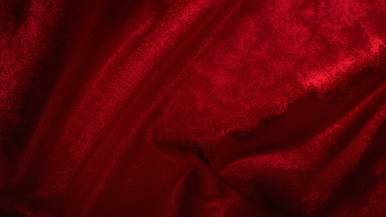 Tessuto di velluto rosso luccicante che mostra una sottile lucentezza mentre la luce soffusa cambia in studio, con pieghe