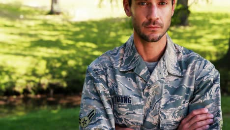 Portrait-of-soldier-standing-with-arms-crossed-in-park