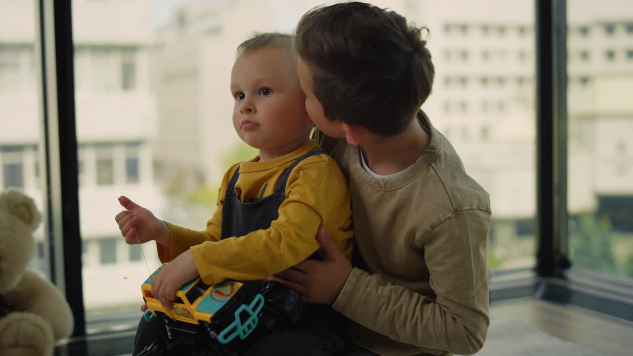 hermanos lindos sentados en el suelo en casa. hermanos jugando juntos.