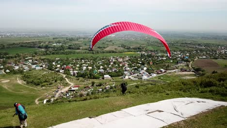 paragliding in the mountains. green fields, hills