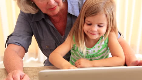 Grandmother-using-laptop-with-her-granddaughter