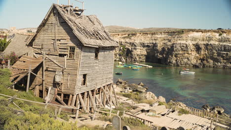 Old-ruined-wooden-house-on-wooden-poles,Popeye-village,Malta,sea-shore