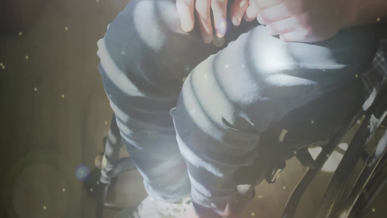 체어에 앉아 있는 장애인 백인 남성 위에 빛의 반점이 그려져 있습니다.