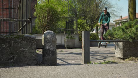 young man passing by narrow entry riding e-scooter on peaceful residential area