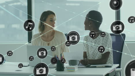 animación de iconos conectados sobre diversas trabajadoras que discuten informes en el escritorio