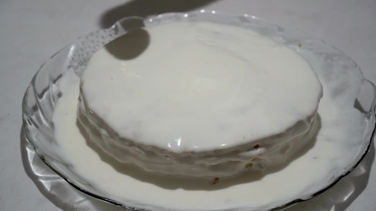 요리사는 케이크 위에 색 크림을 부어, 유리판 위에 케이크를 부어, 달한 디저트를 준비하고, 가까이에서, 위쪽의 전망, 4k.