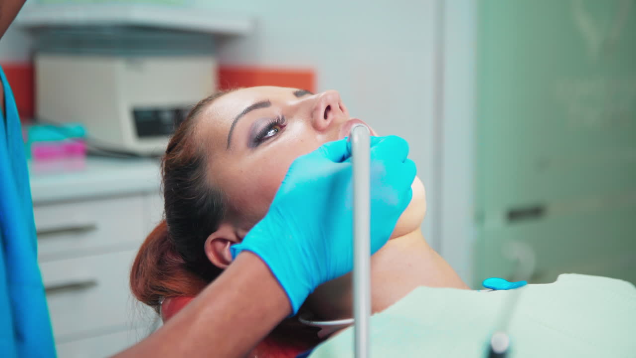Doctor using a device in the dental office with patient at the examination