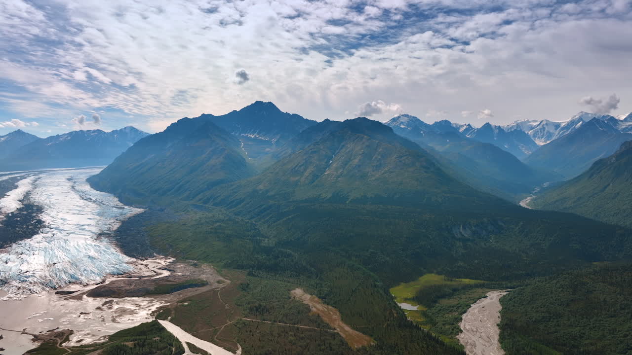 Spectacular scenery of Alaska wilderness from drone. View on the hazy mountains, glacier at the foot and overcast sky