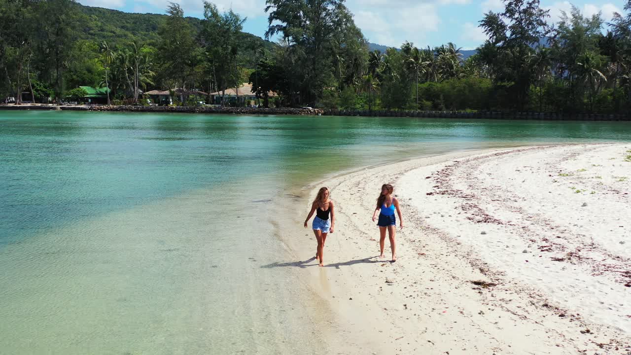 Sexy girls walking barefoot through the soft sand on the Thailand Coast. Koh Phangan island lagoon