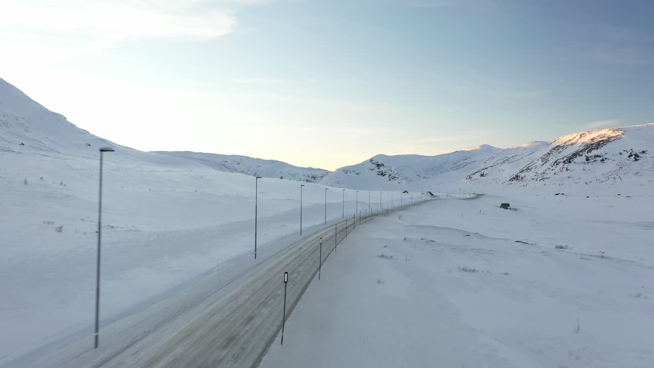동쪽과 서쪽 사이의 hemsedal 산의 eldervatn에서 노르웨이 겨울 도로 교차 - 해가 지는 공중 교차 및 눈 인 도로 위를 날아가는