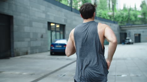 Fit-man-running-outdoor-in-slow-motion.-Back-view-of-athlete-man-training-run