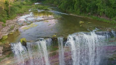 Balls-Falls-Conversation-Area-waterfall-rushes-over-the-edge-of-a-cliff,-surrounded-by-layers-of-rockbed,-green-trees-and-a-rich,-thriving-ecosystem