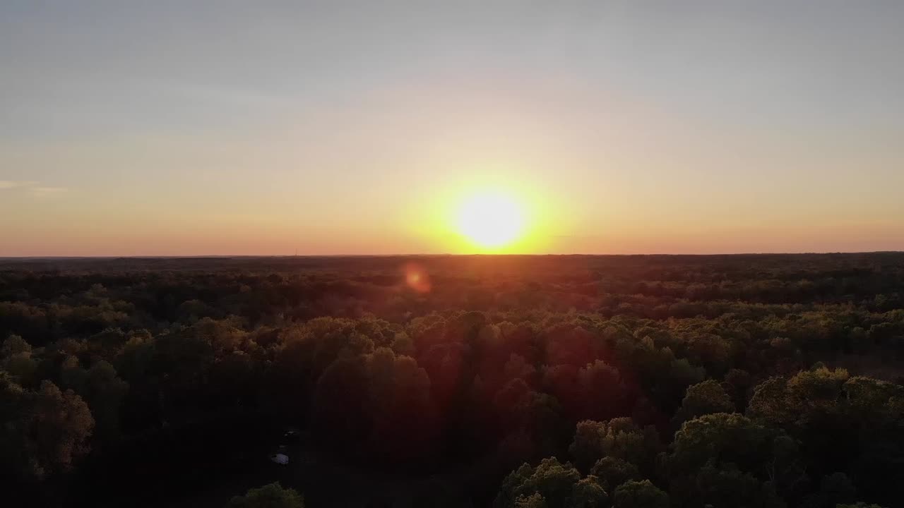 Flying into the sun over the trees with a drone