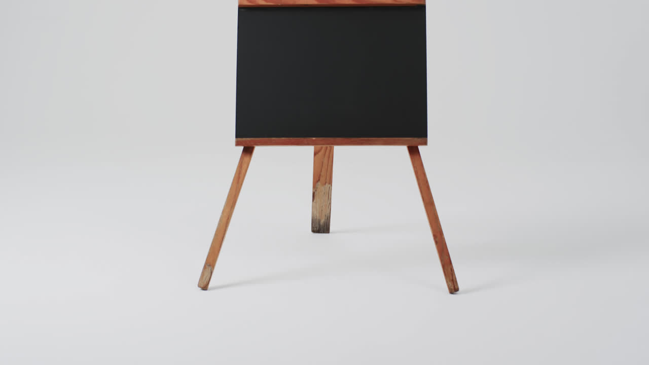 video de un letrero de pizarra en un soporte de madera con espacio de copia en un fondo blanco