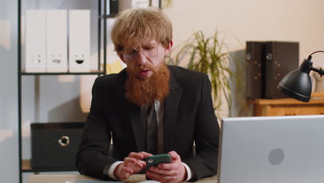 Young office business man use smartphone surprised by bad news fortune loss fail lottery results