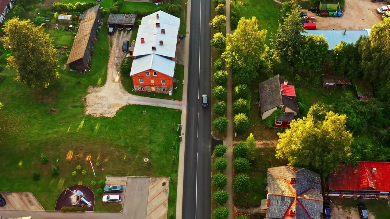 Vista aerea che mostra case, strade, veicoli e aree verdi in un'area urbana sviluppata.