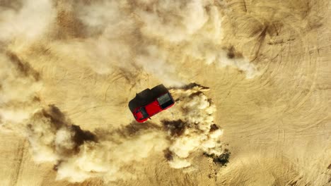 off-road four-wheel drive club kicking up dust in the desert sand - straight down aerial view