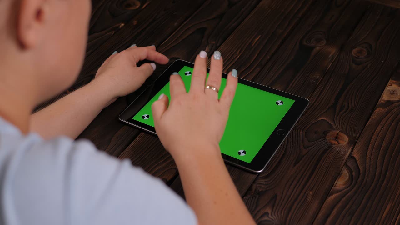 primer plano de una mujer joven usando una tableta con una pantalla verde.