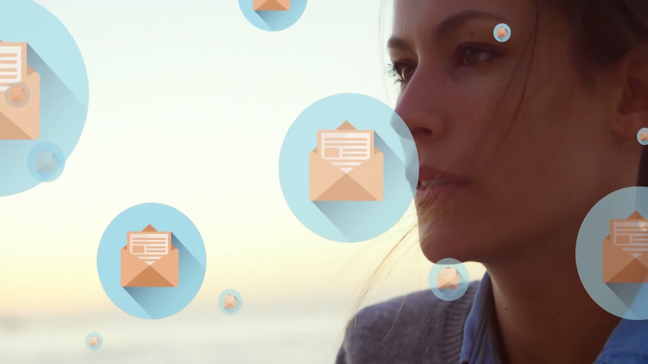 animación de iconos de mensajes flotando sobre el primer plano de una mujer caucásica soplando arena en la playa.
