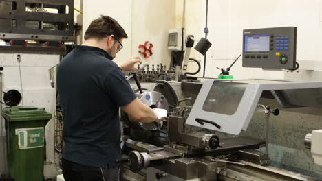 machinist operating a lathe in a manufacturing plant