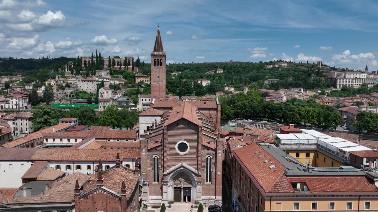 Una splendida ripresa aerea che si allontana dalla Chiesa di Sant'Anastasia a Verona, in Italia, rivelando lo scenario panoramico di Castel San Pietro e l'antico Teatro Romano adagiato lungo la collina