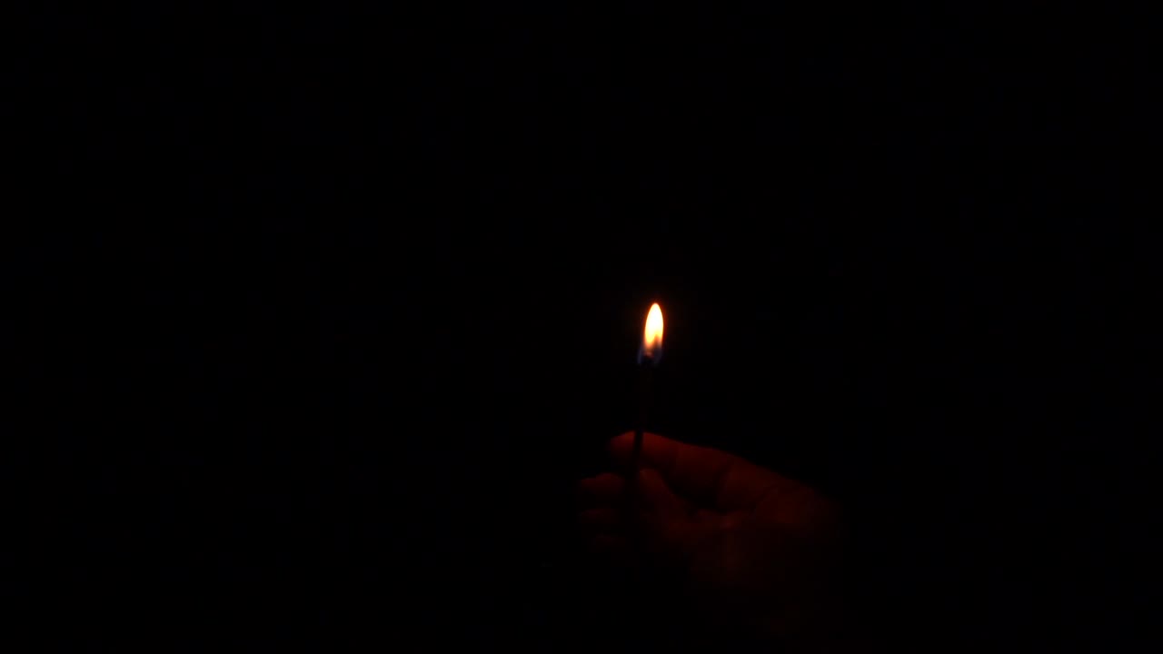Hand holding a match while igniting