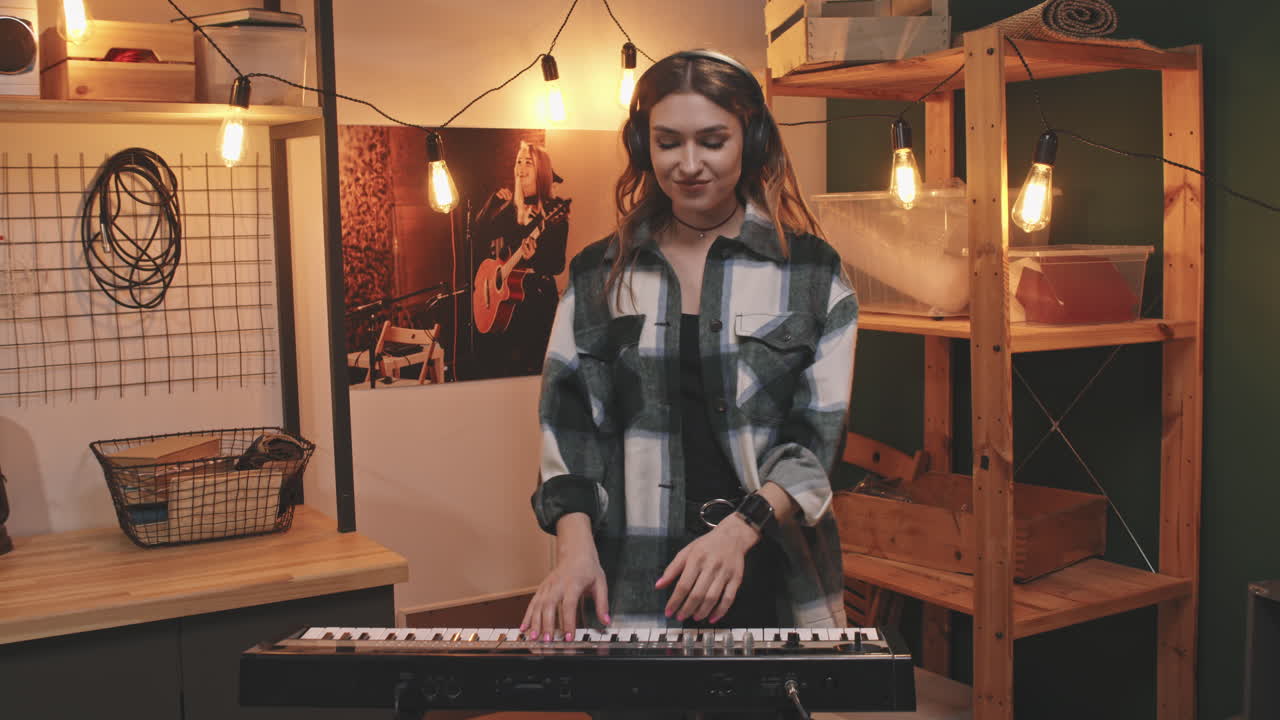Giovane donna con cuffie che suona la tastiera synth
