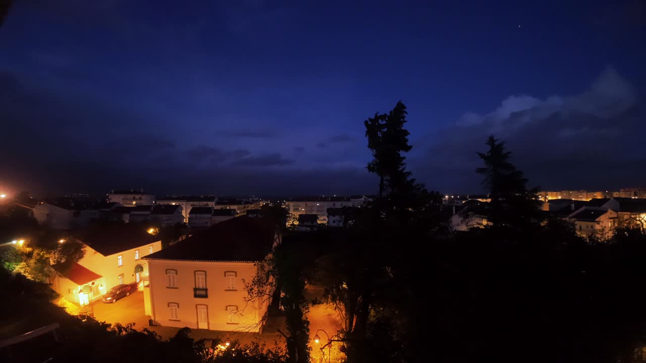Time-lapse dal tramonto alla notte della città con nuvole in movimento e luci urbane.