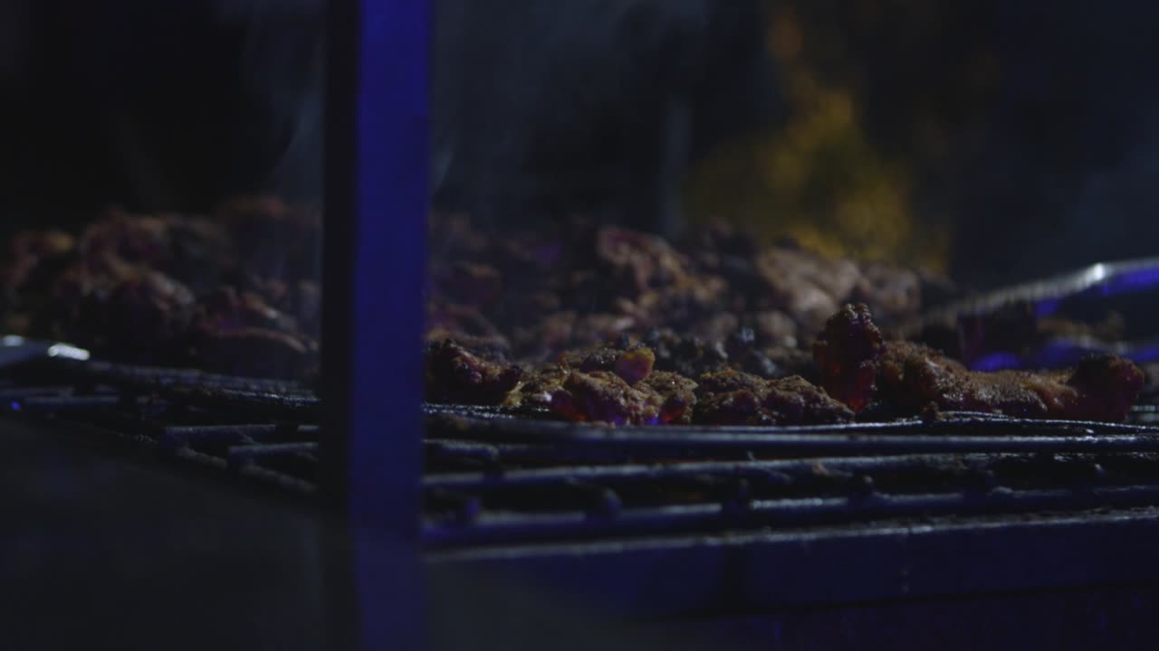 Pollo grigliato su fuoco di notte, fumo, senza fiamma, in primo piano medio